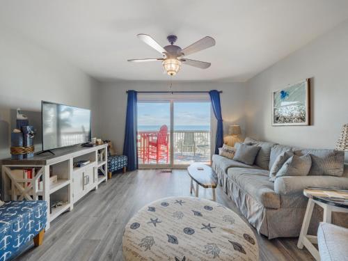 a living room with a couch and a tv at Ocean Dunes 1402 in Kure Beach