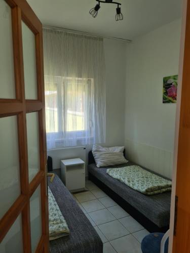 a room with two beds and a window at Zseki apartman in Hajdúszoboszló