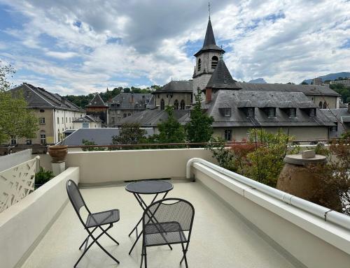 Un balcón con dos sillas y una mesa en un edificio. en Ma terrasse sur le musée, en Chambéry