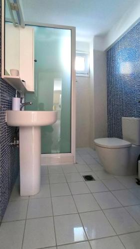 a bathroom with a sink and a tub and a toilet at Michaela's apartment in Fanari in Fanari