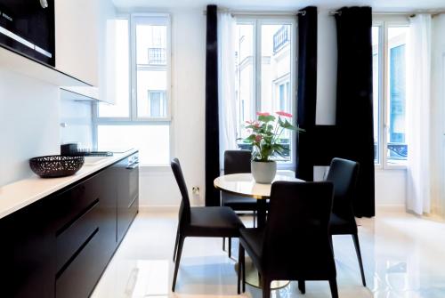 une cuisine et une salle à manger avec une table et des chaises dans l'établissement Champs-Élysées Executive Apartment, à Paris