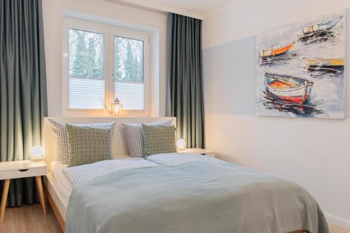 a bedroom with a bed and a painting on the wall at Ferienwohnung Urlaubsflair in Timmendorfer Strand