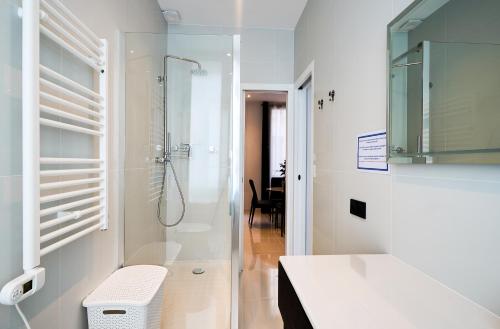 une salle de bain blanche avec douche et toilettes dans l'établissement Champs-Élysées Executive Apartment, à Paris