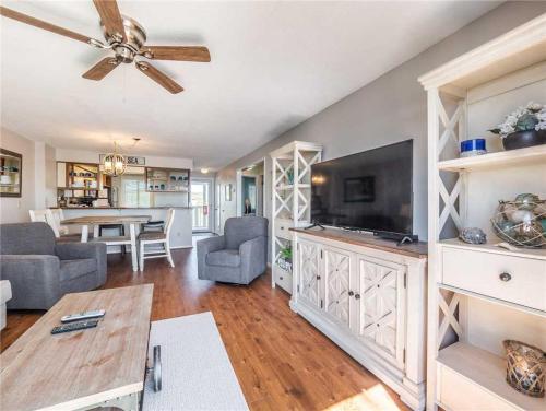 a living room with a flat screen tv and a table at Ocean Dunes 2112 in Kure Beach