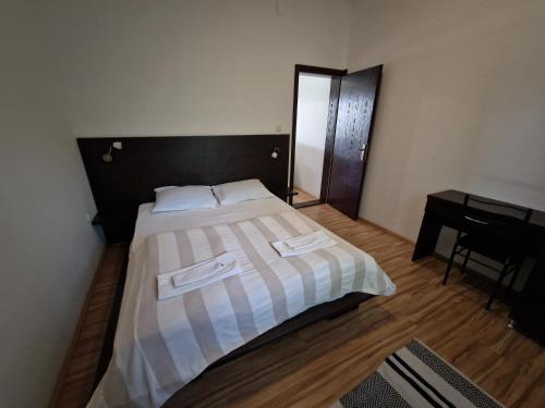 a bedroom with a bed with two white towels on it at Stars Palić in Palić