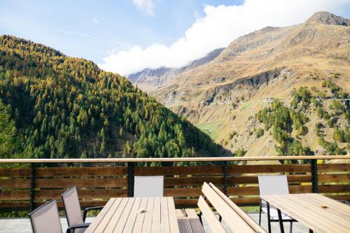 a balcony with a table and chairs and mountains at Gasthof Schönau in Moso