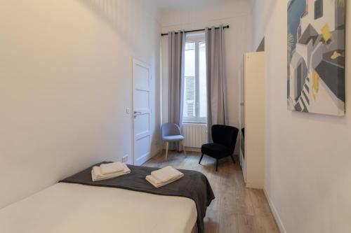 une petite chambre avec un lit et une chaise dans l'établissement L25 Suite au cœur de la Vieille Ville- 2 SDB, à Nice