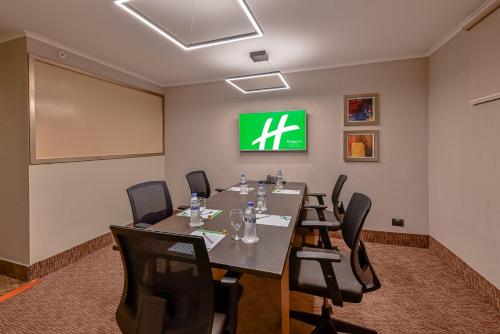 a conference room with a table and chairs and a screen at Holiday Inn San Jose La Sabana by IHG in San José
