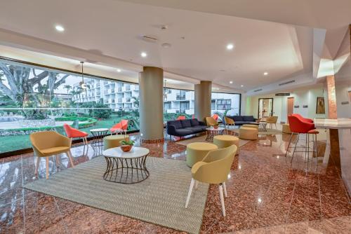 a lobby with colorful chairs and tables in a building at Holiday Inn San Jose La Sabana by IHG in San José