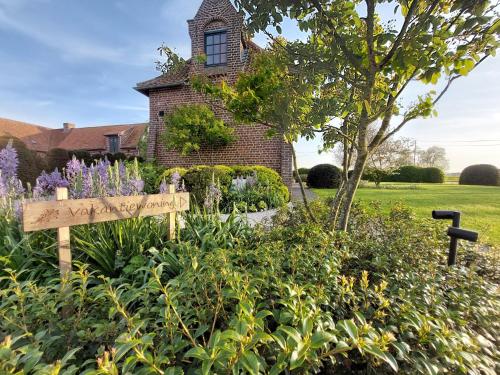 a garden with a sign in front of a house at Landhuis Eikenburg in Ypres