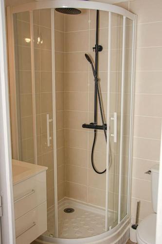 une douche avec une porte vitrée dans une salle de bain dans l'établissement Appartement Narbonne centre, à Narbonne