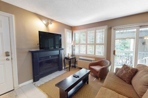 a living room with a fireplace and a tv at Condo 904 at North Creek Resort in Blue Mountains