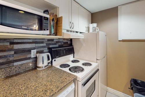 una cocina con estufa y microondas en Condo 904 at North Creek Resort, en Blue Mountains