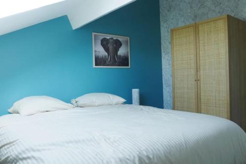 - une chambre bleue dotée d'un grand lit avec des draps blancs dans l'établissement Cosy Bella appartement proche PartDieu, à Villeurbanne