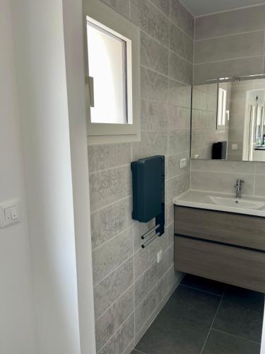 une salle de bain avec un lavabo et un miroir dans l'établissement Villa Maurice, à Valras-Plage