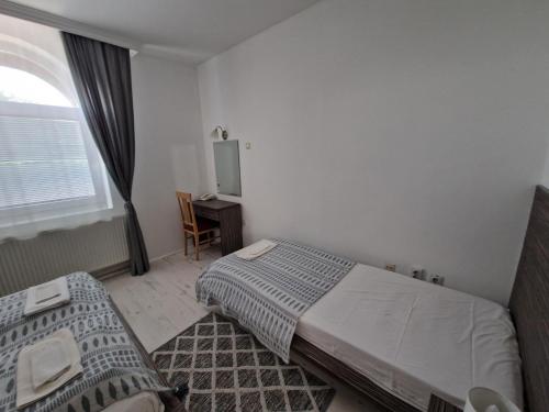 a hotel room with two beds and a window at Stars Palić in Palić