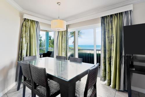 a dining room with a table and chairs with a view of the ocean at Holiday Inn Resort Grand Cayman by IHG in George Town