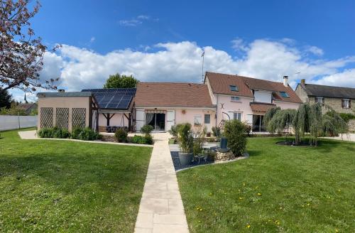 a house with solar panels on the roof at Une parenthèse fleurie in La Heunière