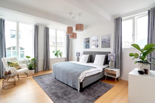 a bedroom with a bed and a chair and windows at Eksklusiv-nordisk-topbelligenhed in Copenhagen