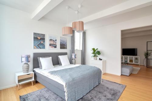 a white bedroom with a bed and a tv at Eksklusiv-nordisk-topbelligenhed in Copenhagen