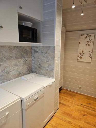 une cuisine avec des armoires blanches et un comptoir dans l'établissement Studio cosy proche plage et centre ville, à Houlgate