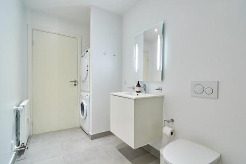 a white bathroom with a toilet and a sink at Eksklusiv-nordisk-topbelligenhed in Copenhagen