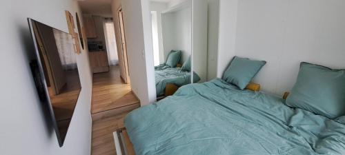 une petite chambre avec un lit et un miroir dans l'établissement Charmant studio neuf Ajaccio Casone - Trottel, à Ajaccio