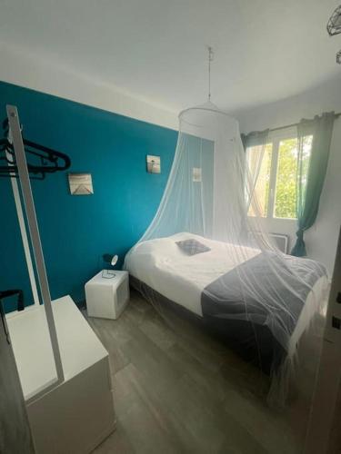 une chambre avec un lit et un mur bleu dans l'établissement le rêve Marin appart t2 proche plage, à Palavas-les-Flots