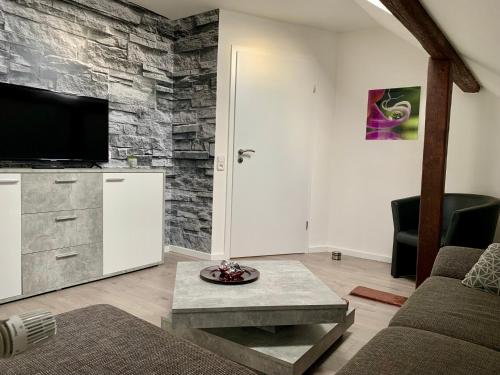 a living room with a tv on a stone wall at Ferienwohnung Eifel-Life in Simmerath