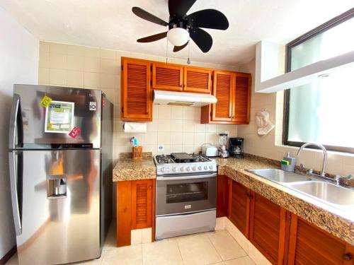 a kitchen with a stainless steel refrigerator and a sink at Villa Ángeles - Elegancia en la Zona Hotelera in Cancún