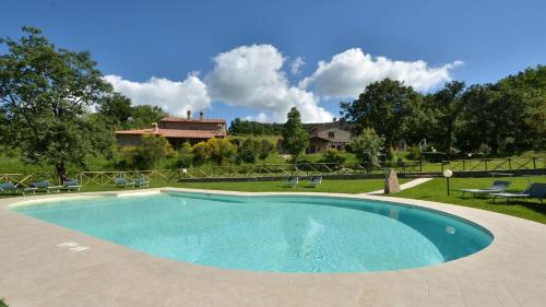 a swimming pool with chairs and a house in the background at Noce in Roccalbegna