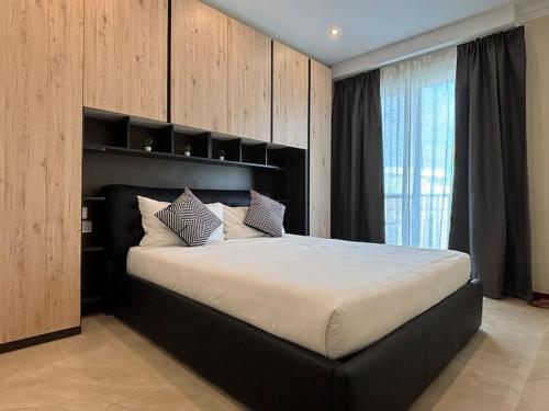 a bedroom with a large bed with a black headboard at San Anton Gardens 3BDR Apartment in Balzan