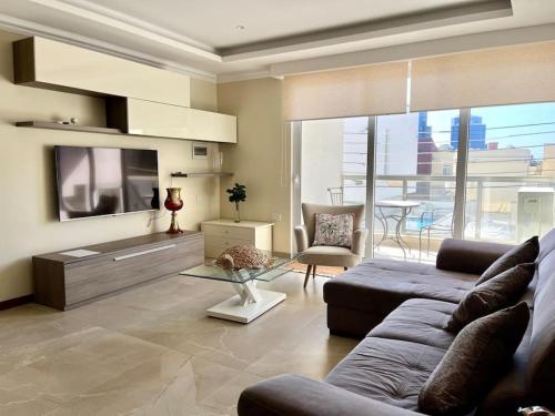 a living room with a couch and a tv at San Anton Gardens 3BDR Apartment in Balzan