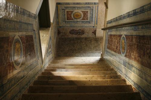 a staircase in a building with a painting on the wall at Palacio Ramalhete in Lisbon
