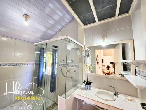 a bathroom with a shower and a sink at Hibiscus Prumirim Chalés in Ubatuba