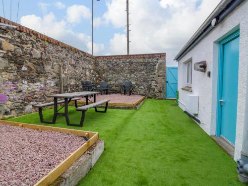 a patio with a table and green grass at 2 College Bounds in Fraserburgh