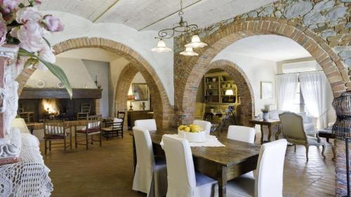 a dining room with a table and chairs and a kitchen at Villa Il Colto in Terranuova Bracciolini