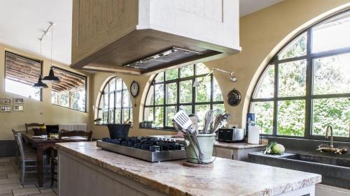 a kitchen with windows and a counter with a sink at Villa Il Colto in Terranuova Bracciolini