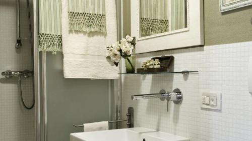 a bathroom with a sink and a vase of flowers at Villa Il Colto in Terranuova Bracciolini