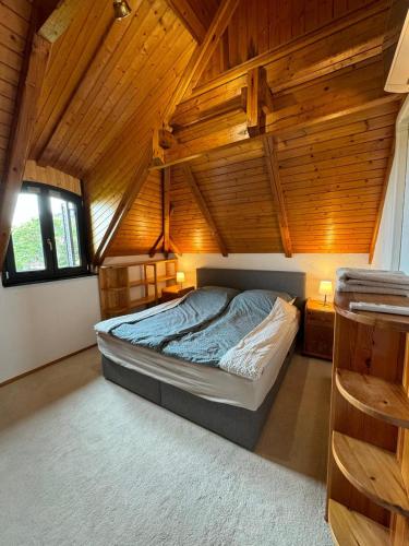 a bedroom with a bed in a wooden ceiling at Top Hill Balaton in Badacsonytomaj