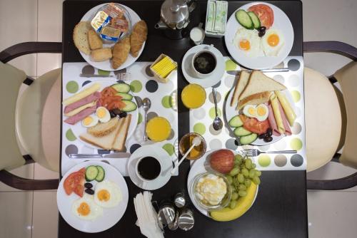a table with plates of breakfast foods on it at Epidavros Hotel in Athens