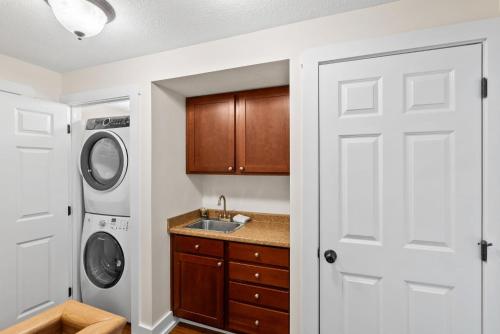 a kitchen with a sink and a washer and dryer at 2 Cabins & Views for Miles Hot Tubs Pool Table in Swiss