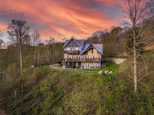 an aerial view of a large house on a hill at 2 Cabins & Views for Miles Hot Tubs Pool Table in Swiss
