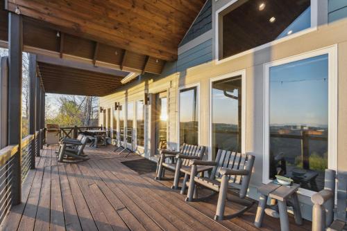 a deck with chairs and windows on a house at 2 Cabins & Views for Miles Hot Tubs Pool Table in Swiss