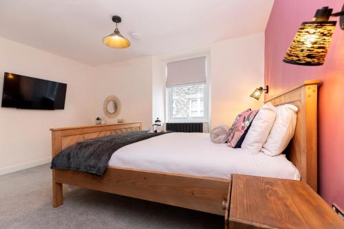 鲍内斯温德米尔Sheila's Cottage Bowness的一间配有大床和平板电视的卧室