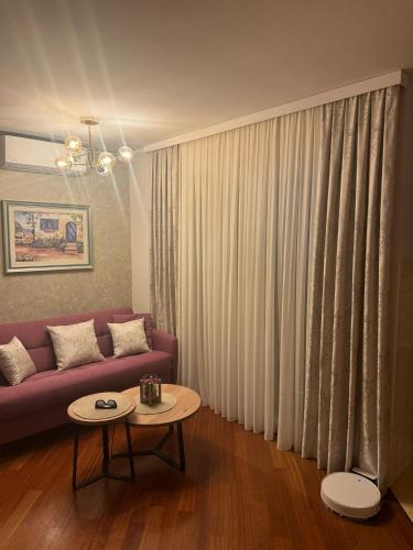 a living room with a purple couch and a table at Apartmani PENAVIĆ in Makarska