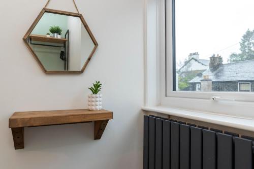 鲍内斯温德米尔Sheila's Cottage Bowness的一面靠窗的墙上的镜子