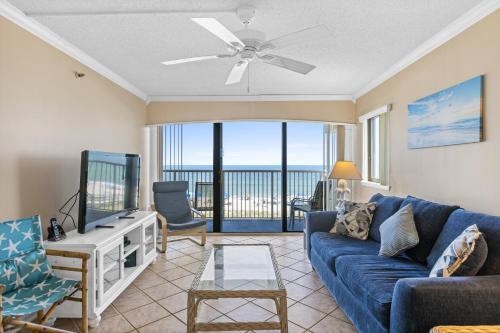 a living room with a blue couch and a tv at Pelican Watch #307 in Carolina Beach