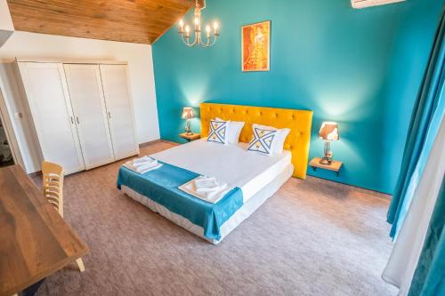 a bedroom with a large bed with blue walls at Royal Calisto Hotel in Sozopol