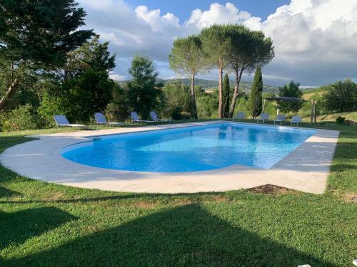 a swimming pool in a yard with chairs around it at Villa Il Turchetto in Manciano